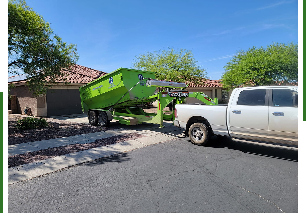 Truck towing a green trailer in driveway.